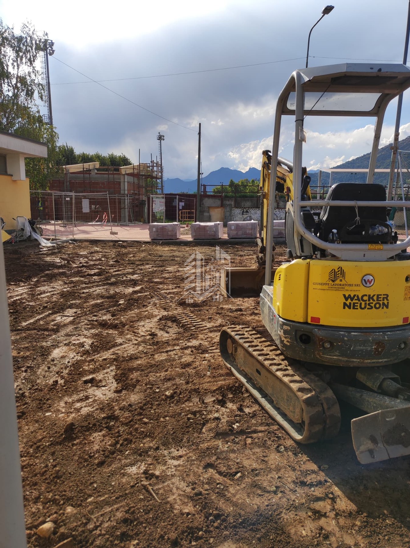 Mini escavatore Wacker Neuson con marchio aziendale in cantiere