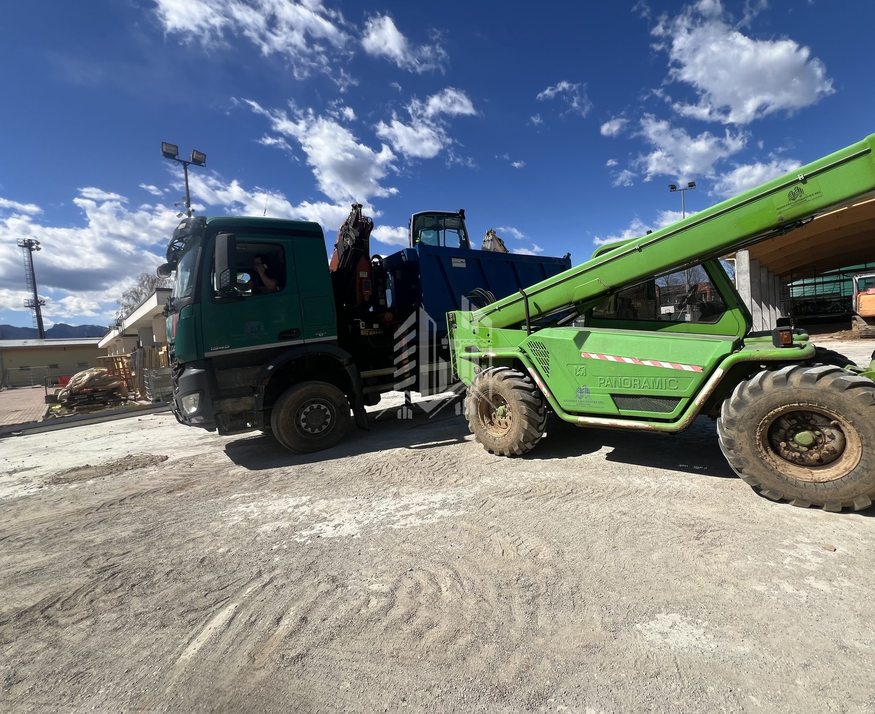 Camion con ribaltatore e carrello elevatore telescopico Merlo Panoramic con marchio aziendale